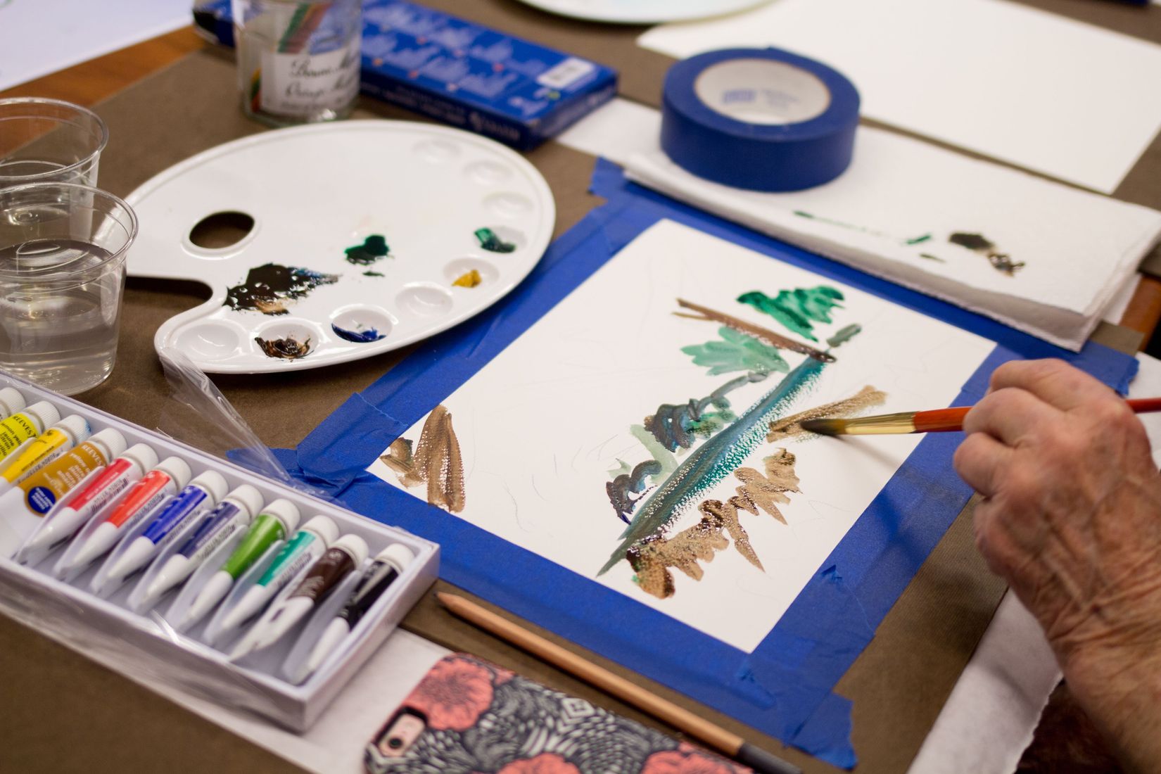 A watercolor palette and canvas.